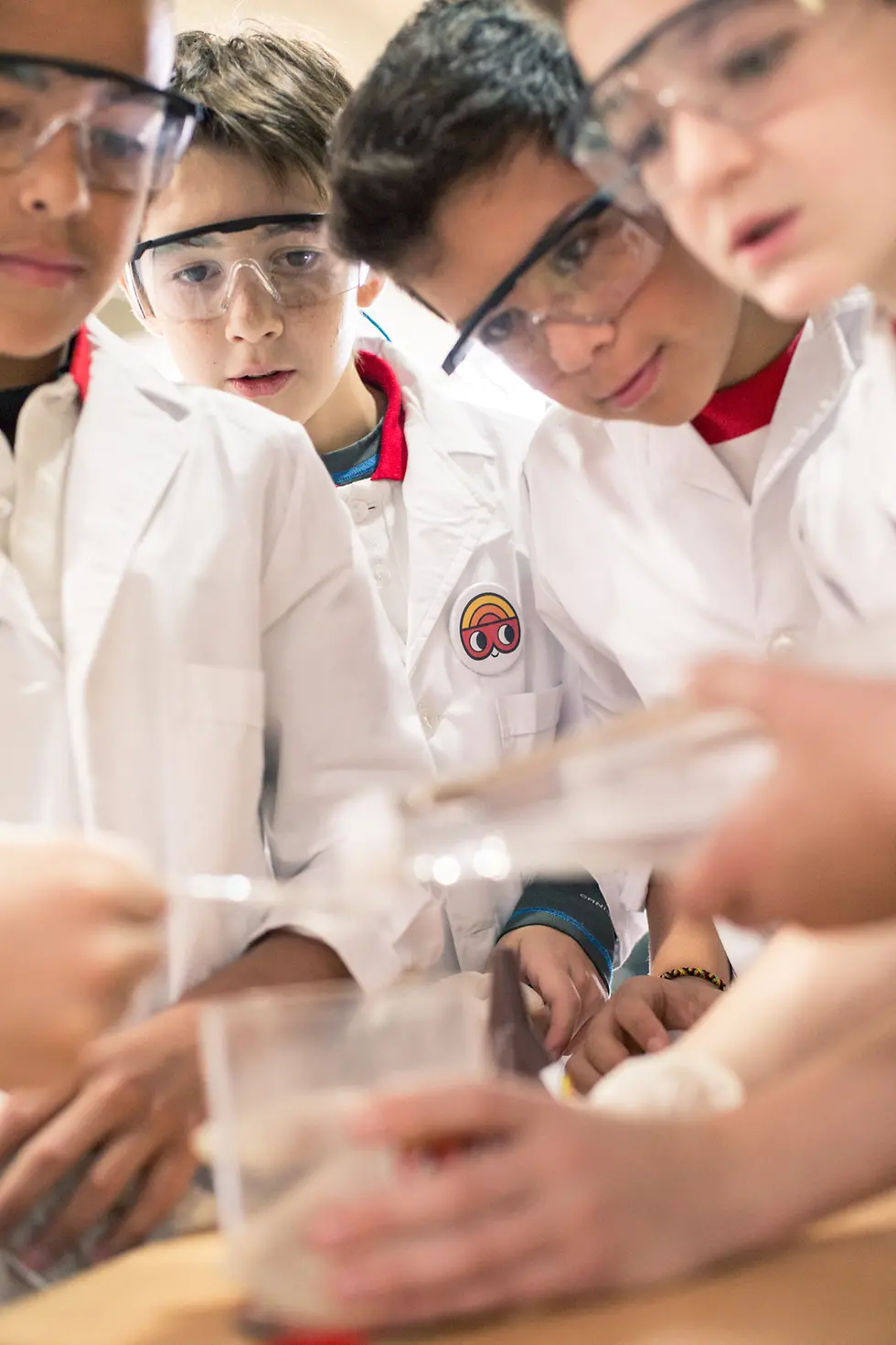 Four boys watch an experiment in the Forscherwelt in Argentina.