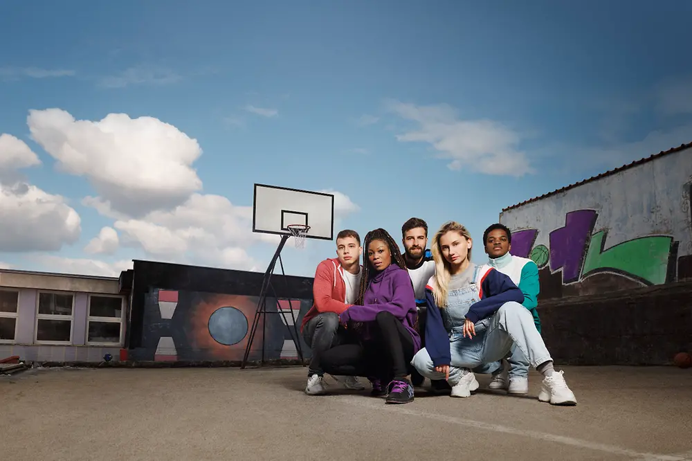 Group of diverse individuals playing a basketball team dressed in athletic apparel