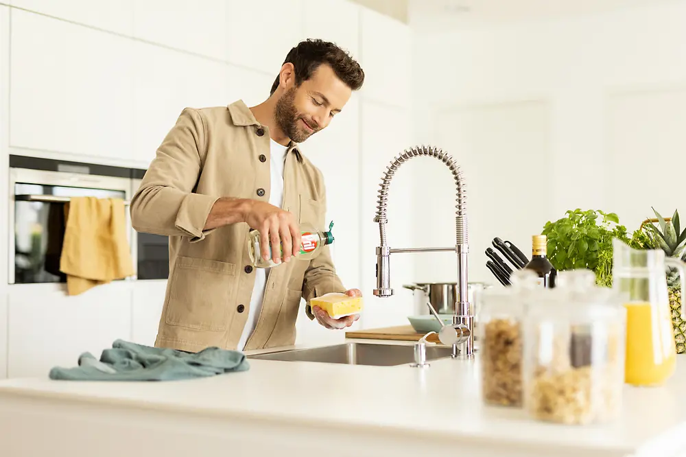 Man in kitchen doing the dishes