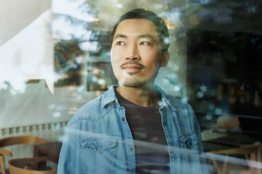 A man looks through a glass window.