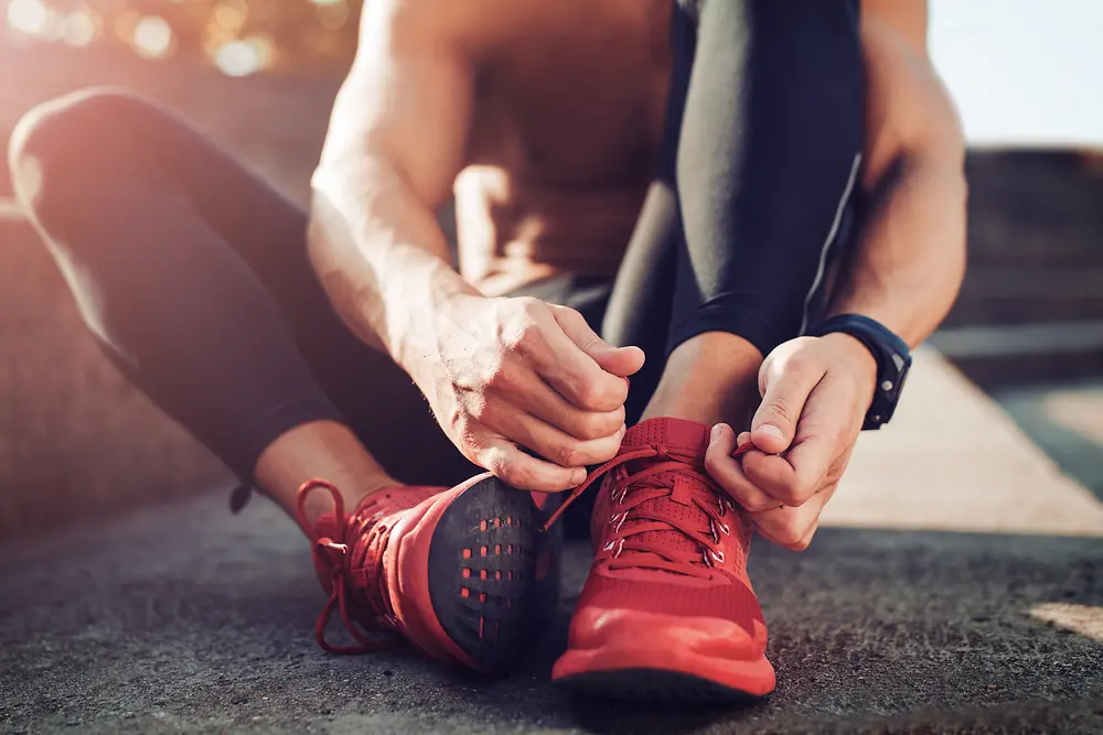 A man tying his red sports shoes