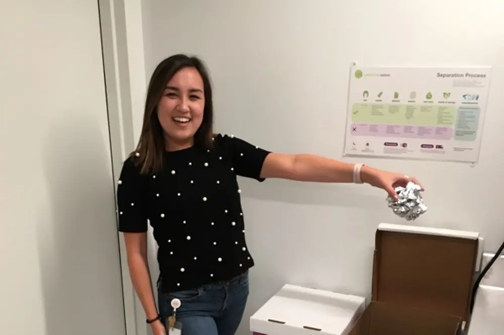 A Henkel employee demonstrates how to properly recycle salon waste using the various bins provided by Green Circle Salons.